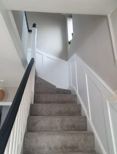 there is a staircase leading up to the second floor with white railing and handrails