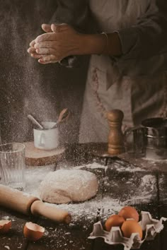 a person sprinkling flour on top of dough