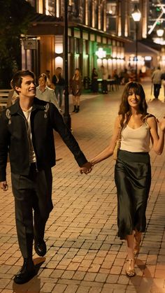 a man and woman walking down the street holding hands