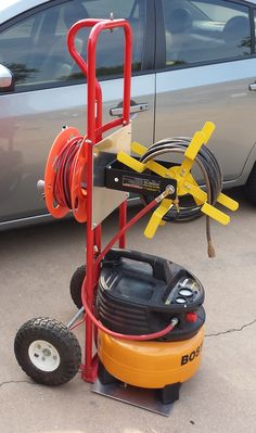 a car is parked next to a portable air mover with wheels and hoses on it