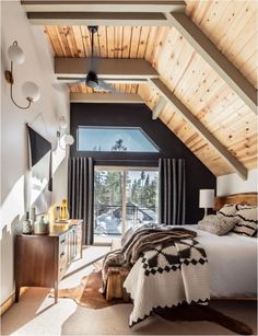 a bedroom with a bed, dresser and window overlooking the snow - covered mountain range