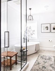 a bathroom with a bathtub, rug and pictures on the wall