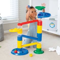 a young child playing with a toy set in the middle of a living room area