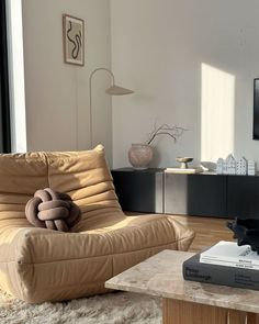 a living room filled with furniture and a flat screen tv mounted on the wall next to a window