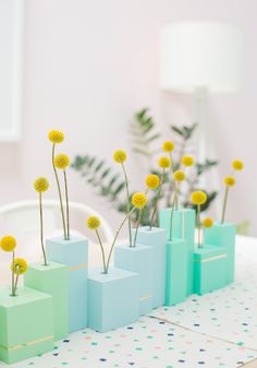 three vases with yellow flowers in them on a table