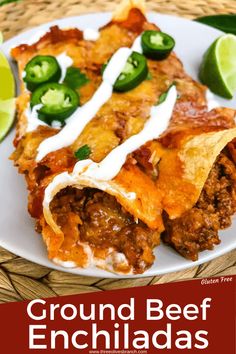 ground beef enchiladas on a plate with sour cream and jalapenos