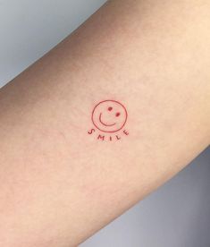 a small smile tattoo on the arm