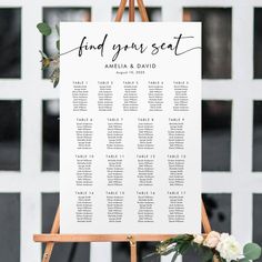 an easel with seating cards and flowers on it