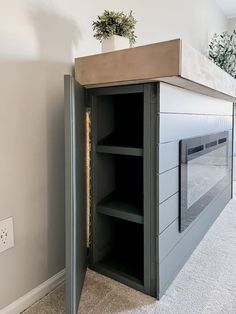 an empty room with a plant on top of the cabinet