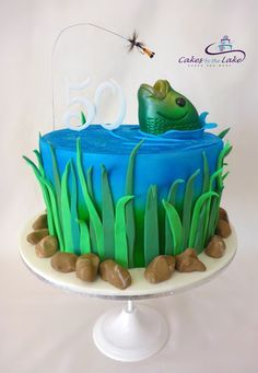 there is a cake that has grass and rocks in the shape of a fish on it