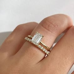 a woman's hand with a gold ring and diamond engagement band on it,