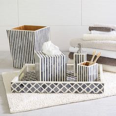 three black and white bathroom accessories sitting on a towel