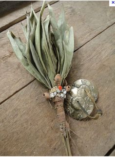 a bunch of dried flowers sitting on top of a wooden table next to a metal object