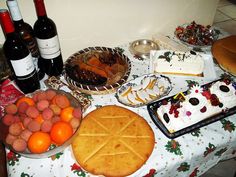 a table topped with lots of food and wine next to bottles of wine on top of a table