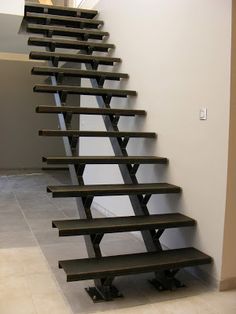 a set of stairs made out of metal and wood in an empty room with tile flooring