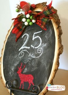 a chalkboard sign with a deer on it is decorated with red and green bows