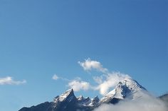 the mountains are covered in snow and clouds