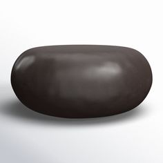 a black rock sitting on top of a white surface