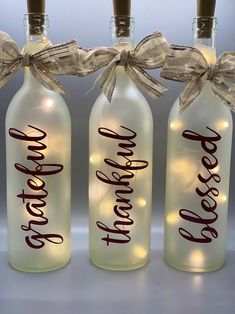 three bottles with lights in them that say happy mother's day and have bows on the top