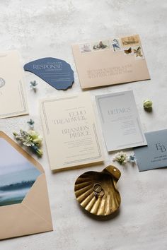 the wedding stationery is laid out on top of the table, including envelopes and cards