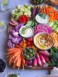 an assortment of vegetables and dips on a platter