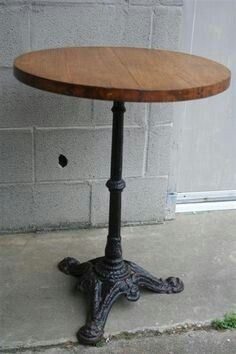 a wooden table sitting on top of a cement floor next to a brick wall and door