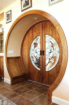 an arched wooden door with stained glass in the center