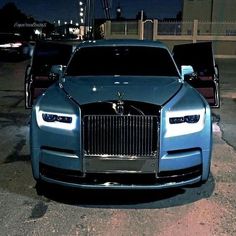 two rolls royces parked next to each other in a parking lot at night time