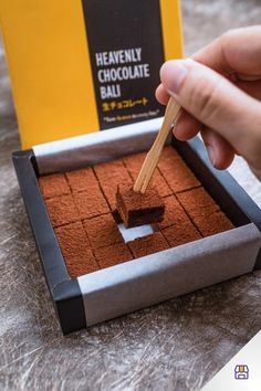 a person is dipping chocolate into some kind of square cake with a spoon in it