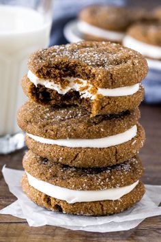 three cookies stacked on top of each other next to a glass of milk