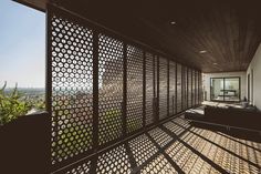 the sun shines through decorative screens on an outdoor patio area with wood flooring