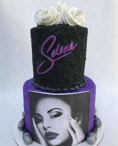 a black and purple cake with an image of a woman's face on it