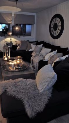 a living room filled with lots of furniture and candles on top of the couches