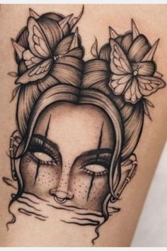 a woman's face with flowers in her hair and eyes on the side of her arm