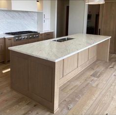 a large kitchen with an island in the middle of it's floor and cabinets