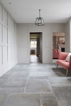 an empty living room with two pink chairs