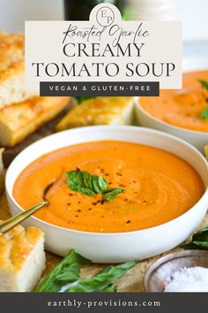 two bowls of creamy tomato soup with bread on the side and text overlay that reads, roasted garlic creamy tomato soup vegan & gluten - free