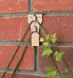 a brick wall with vines growing on it and an electrical device attached to the side