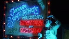 a man standing in front of a sign that reads captain guiding's museum monsters and madmen