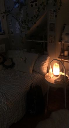 a bedroom with a bed, night stand and lamp in the corner on top of it