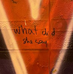 graffiti written on the side of a wall that says, what did she say?