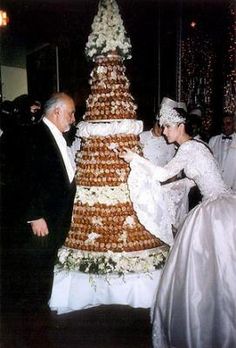 a man and woman standing next to a large cake