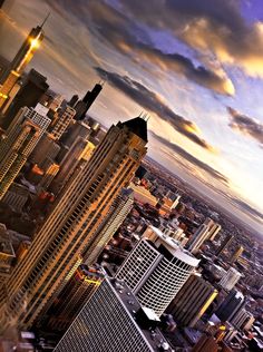 an aerial view of skyscrapers in the city at sunset or dawn with dramatic clouds