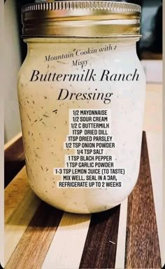 a jar of buttermilk ranch dressing sitting on a wooden counter top with instructions