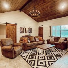 a living room with couches, chairs and a rug on the floor in front of a window