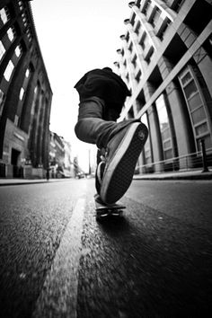 a skateboarder is riding down the street in front of a tall building with words that read, every day is leg day