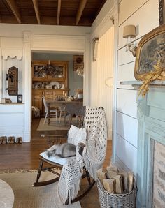 a rocking chair with a cat on it in a living room next to a fireplace