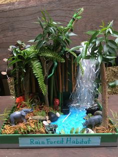 a miniature garden with fake trees and water features in the center, including an elephant fountain