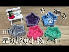 four crocheted baby diapers sitting on top of a wooden floor next to a bench