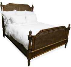 the bed is made with wicker and white linens